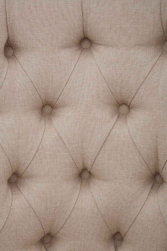 Close-up of a textured beige fabric with buttonhole pattern
