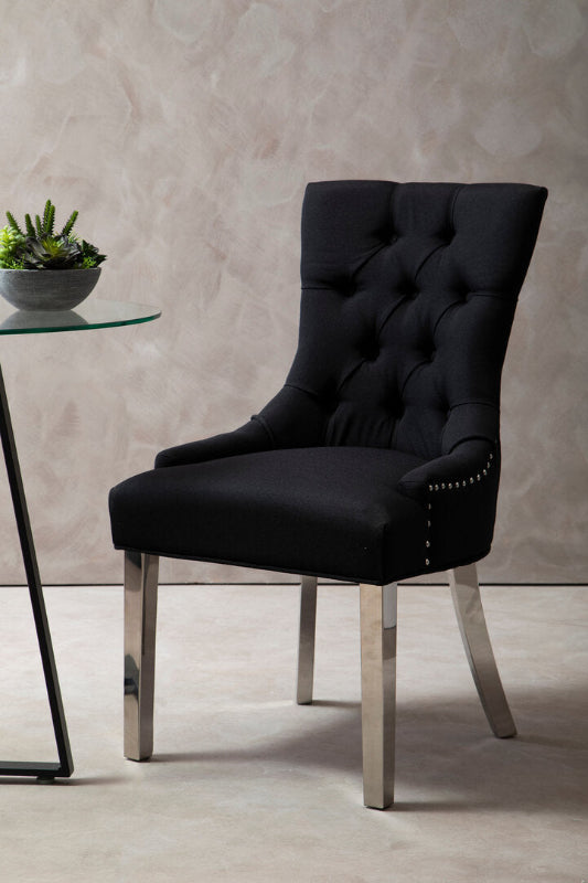 Black upholstered chair with silver legs in a room setting