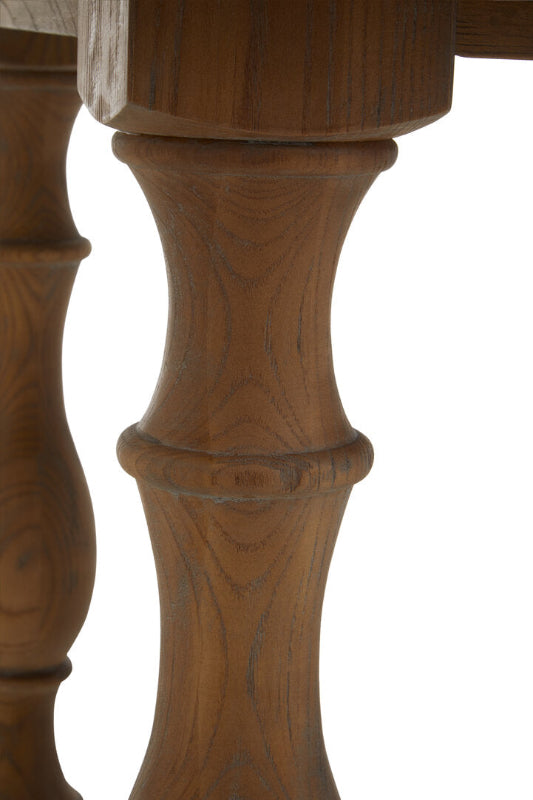 Close-up of a wooden table leg with intricate carvings on a white background