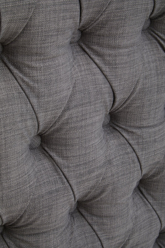 Close-up of a tufted gray fabric surface