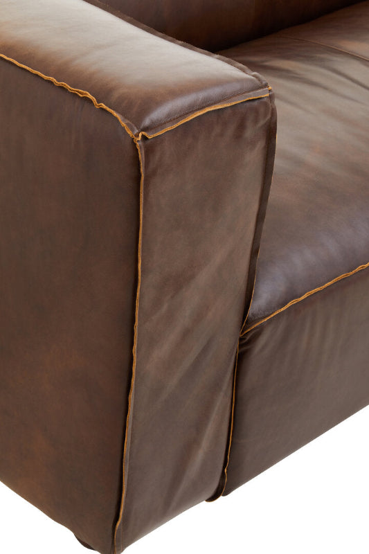 Close-up of a brown leather sofa corner on a white background