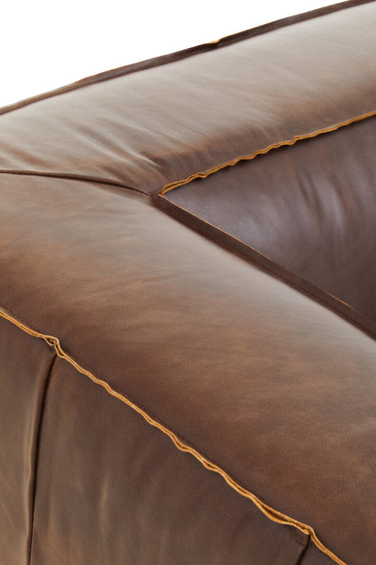 Close-up of a brown leather sofa with visible stitching.