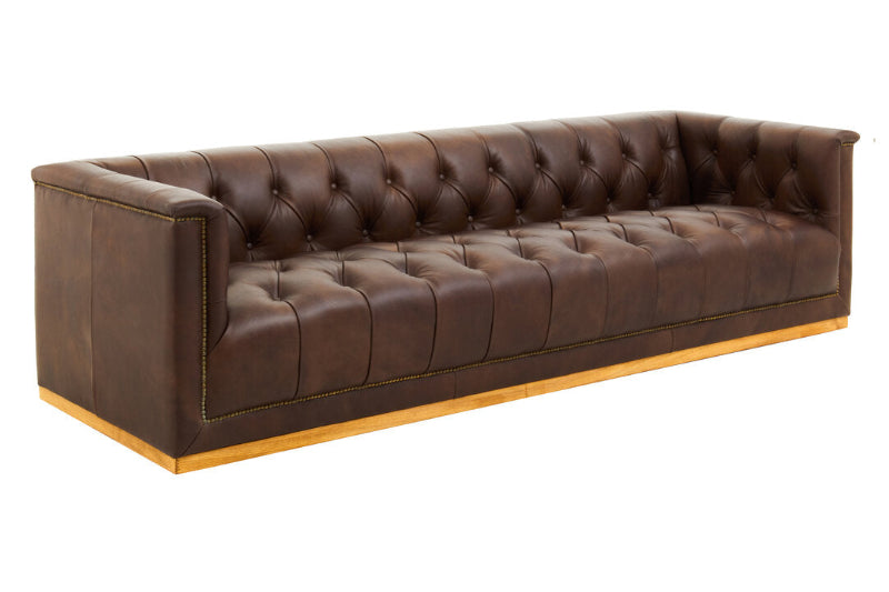 Brown leather sofa with tufted backrest on a white background