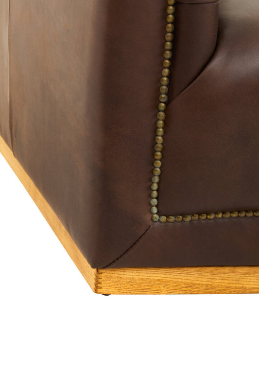 Close-up of a brown leather sofa corner with wooden trim on a white background