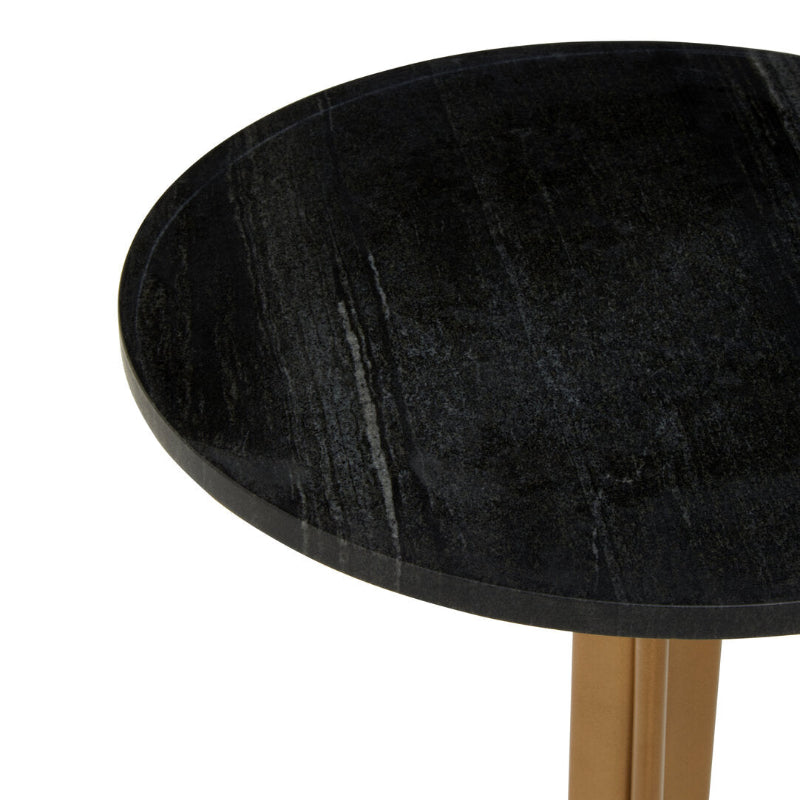 Round black marble table with a gold base on a white background