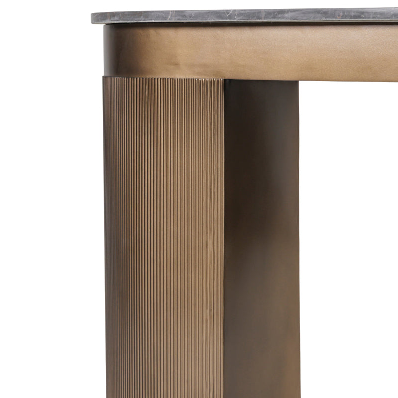 Close-up of a bronze table leg with a textured design on a white background
