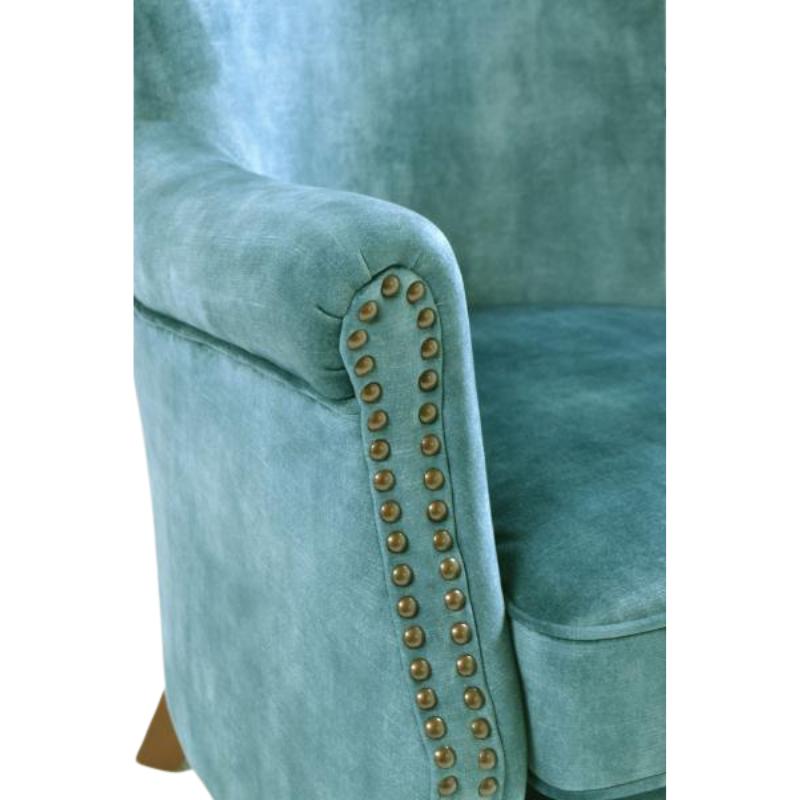 Teal armchair with studded details on a white background
