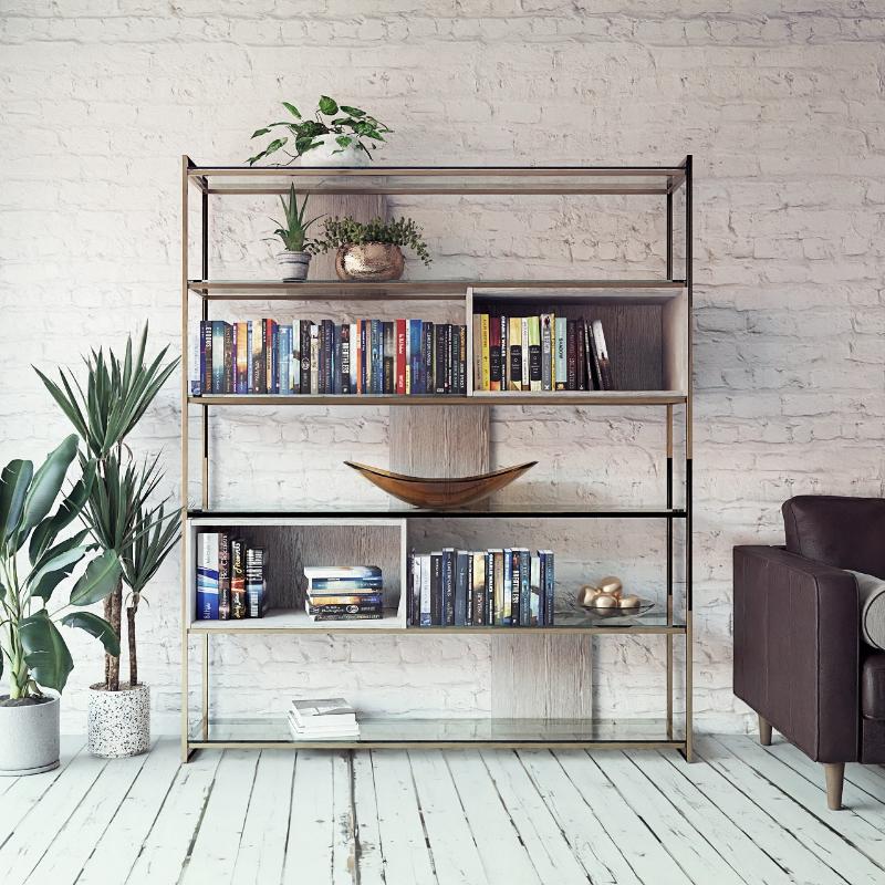 Bookshelf with books and decor items against a white brick wall.