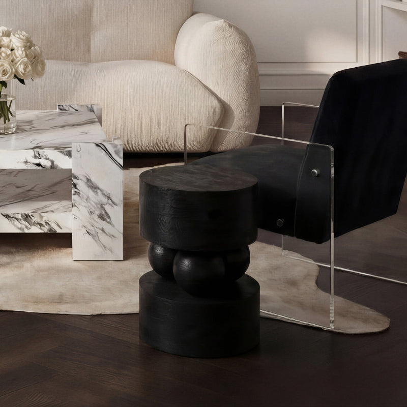 Modern living room with a black chair, black stool, and marble coffee table.