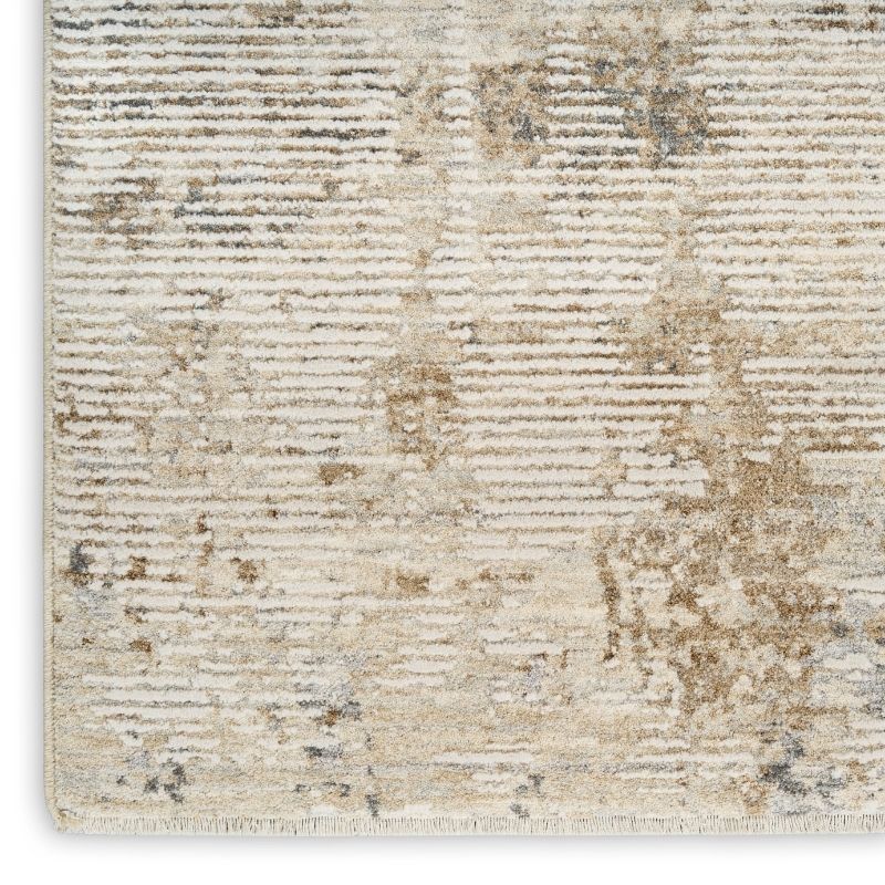 A close-up of a textured area rug with a distressed horizontal stripe pattern in cream, beige, and light gray tones.