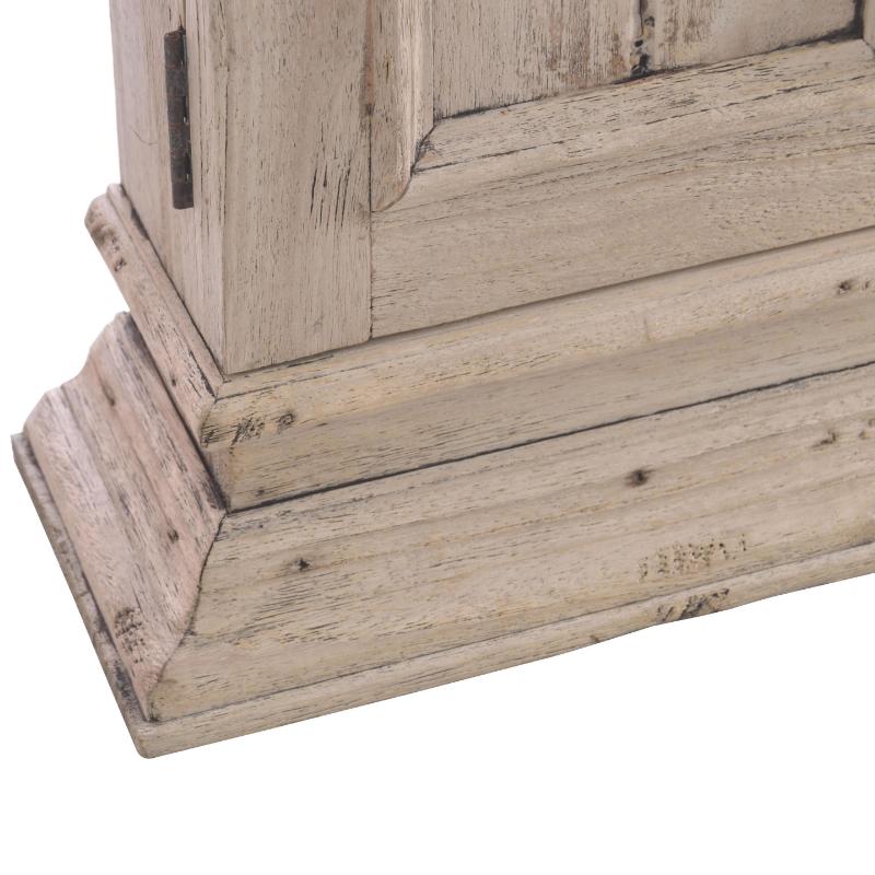 Close-up of a distressed whitewashed wooden furniture corner showing the base and part of the upper frame with visible wood grain and weathered finish.