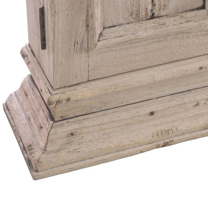 Close-up of a distressed whitewashed wooden furniture corner showing the base and part of the upper frame with visible wood grain and weathered finish.