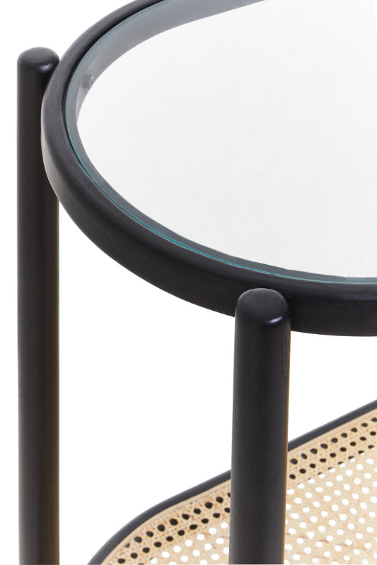 Round glass-top side table with black metal frame and woven base on a white background