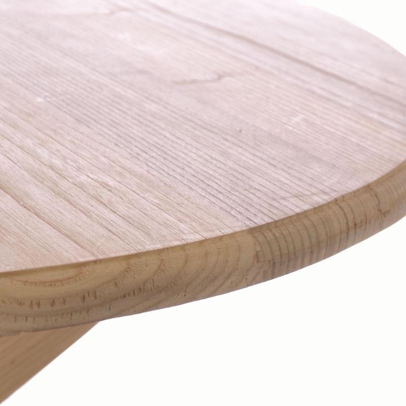 Close-up of a light natural wood tabletop showing the grain and rounded edge against a white background.