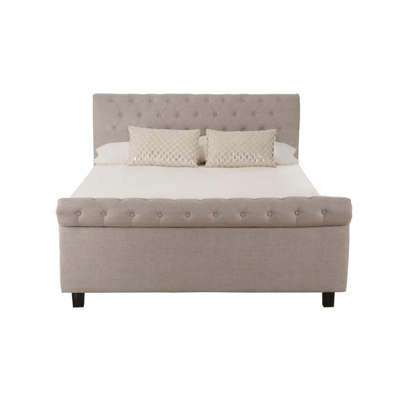 Beige upholstered bed with white bedding on a white background