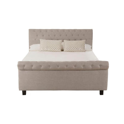 Beige upholstered bed with white bedding on a white background