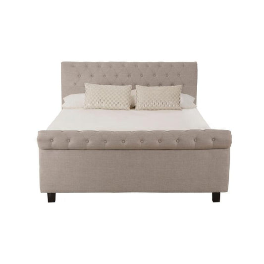 Beige upholstered bed with white bedding on a white background