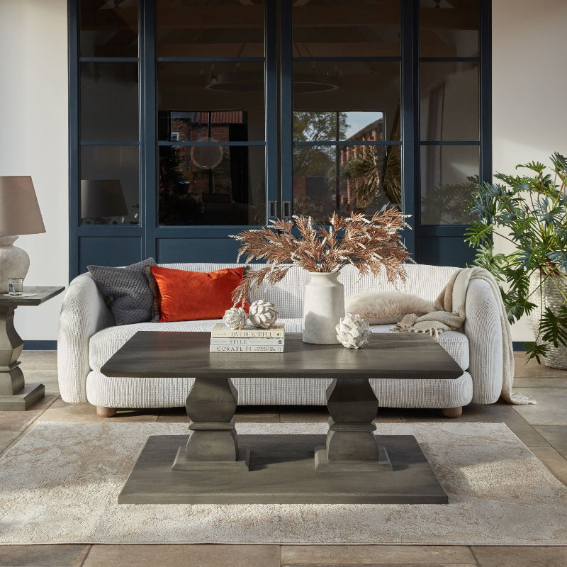 Modern living room with a sofa, coffee table, and decorative elements.