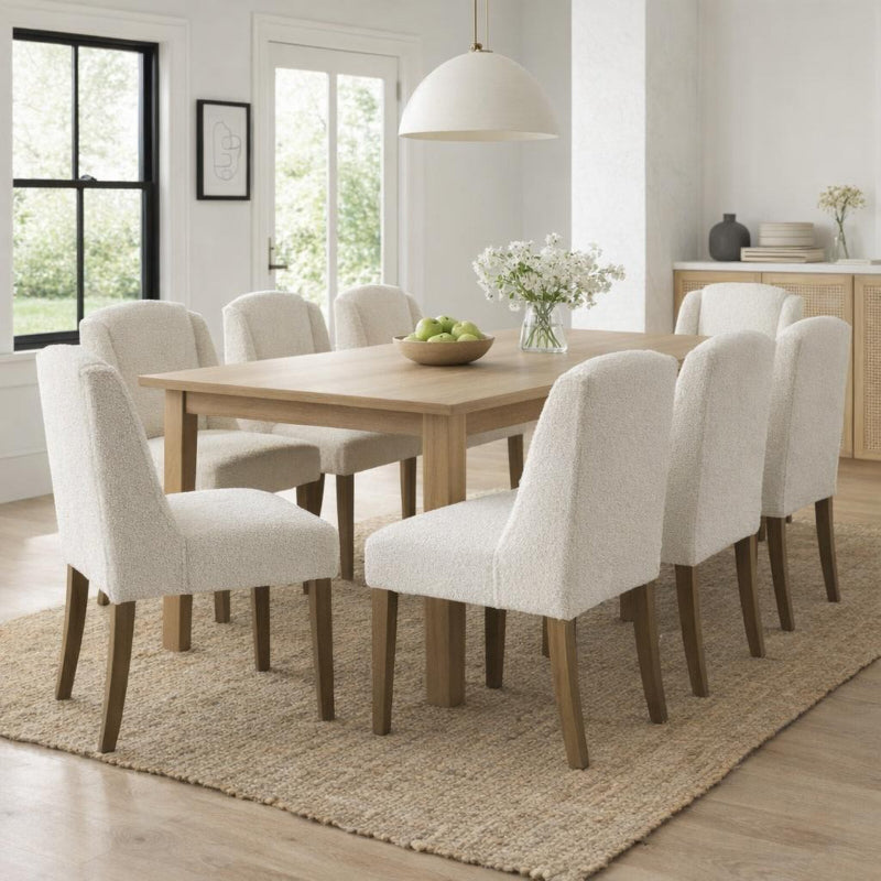 Dining room with wooden table and white chairs on a beige rug.