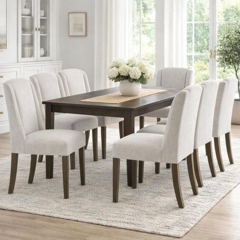 Dining room with a dark wood table and white chairs on a light rug.
