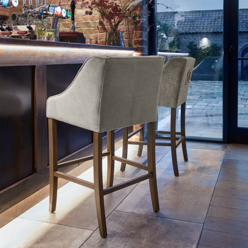 Two bar stools in a bar setting with a view of the outdoors.
