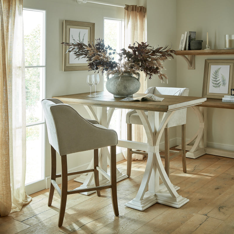 Dining room with a wooden table and chairs, featuring a vase of flowers and books.
