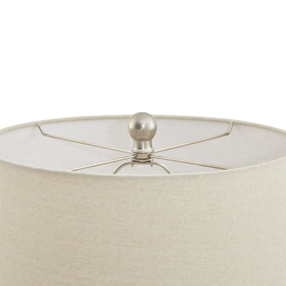Close-up of a cream lampshade with a metallic finial on a white background