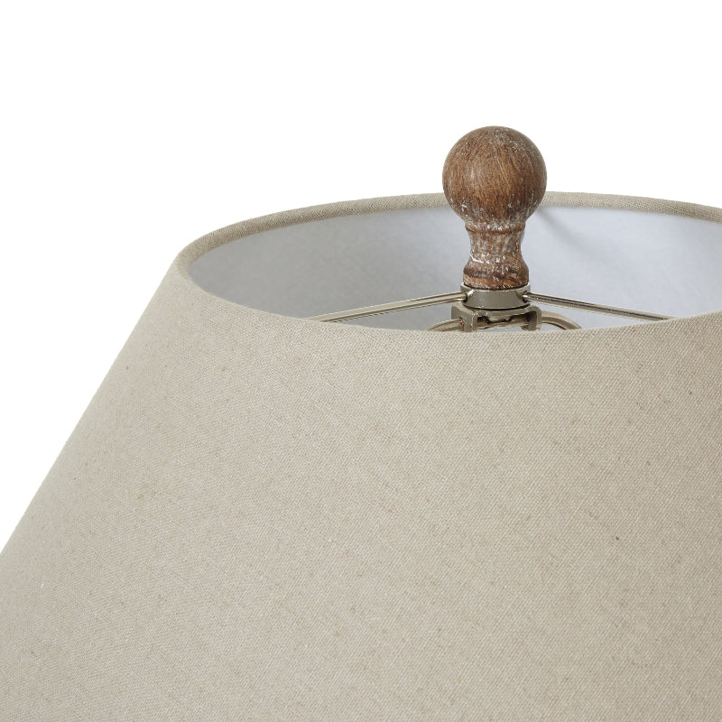 Close-up of a beige lampshade with a wooden finial on a white background