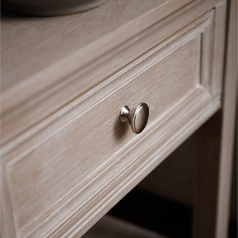Wooden drawer with a metallic handle on a neutral background