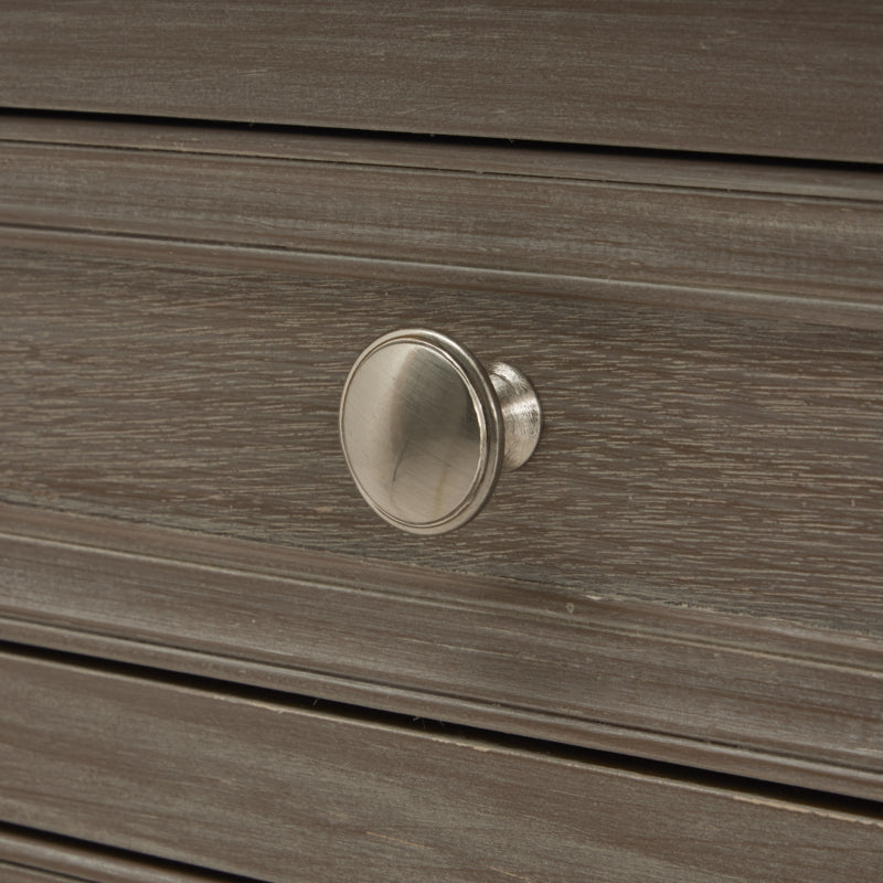 Close-up of a wooden drawer with a silver knob