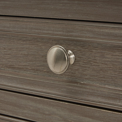 Close-up of a wooden drawer with a silver knob