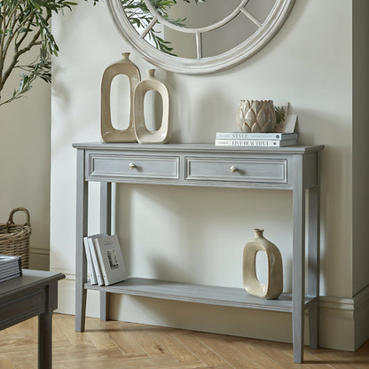 Grey console table with decorative items in a room setting