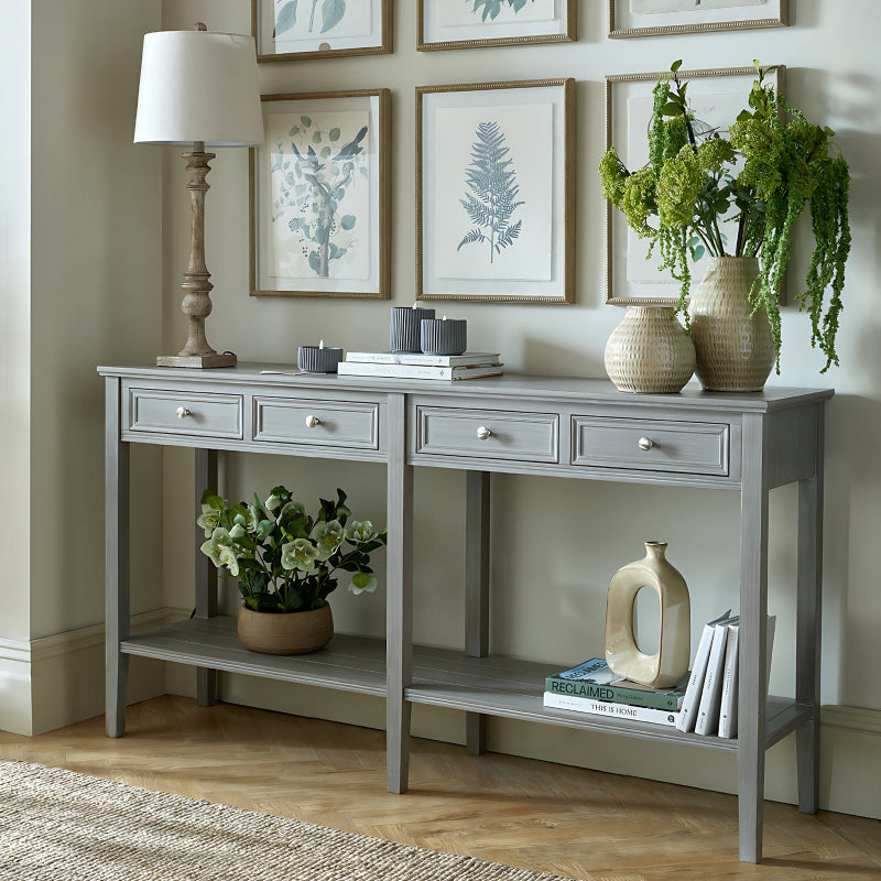 Gray console table with decorative items in a room with framed artwork on the wall.