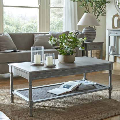 Living room with a grey coffee table, sofa, and decorative items.