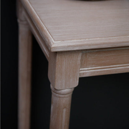 Wooden side table with a decorative item on top against a black background