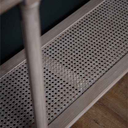 Rattan shelf with wooden legs on a dark background