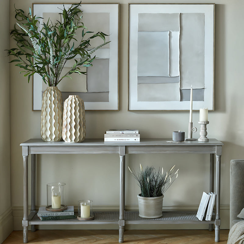 Console table with decorative items against a wall with framed art