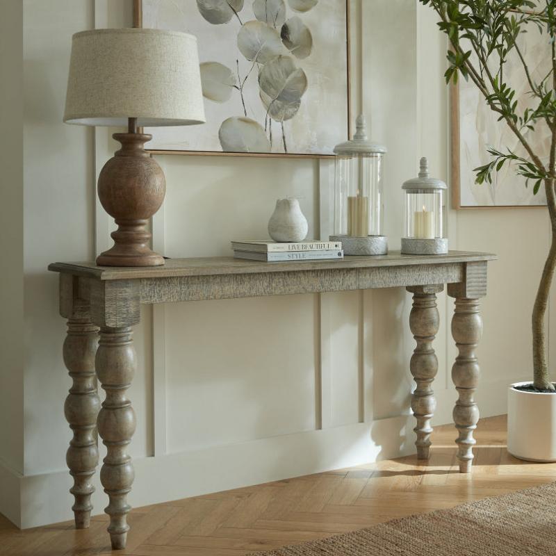 Wooden console table with decorative items in a room setting