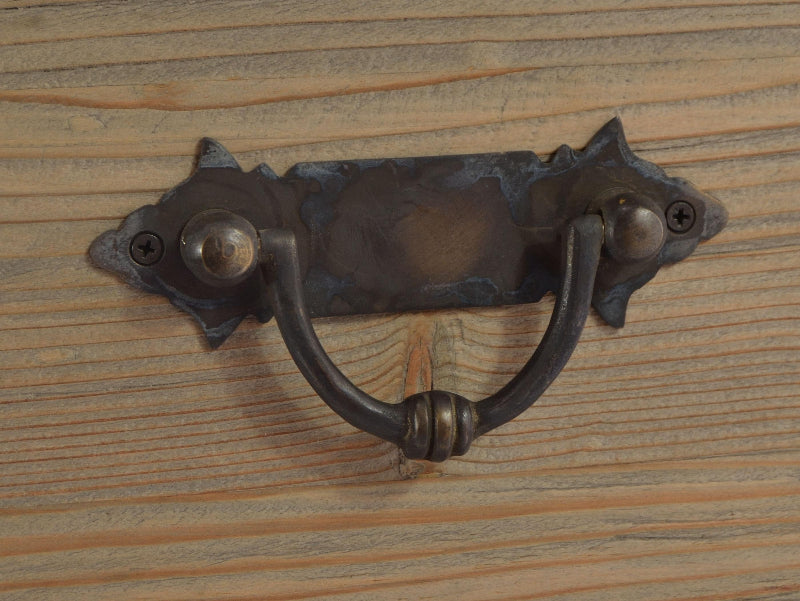 Decorative metal handle on wooden surface