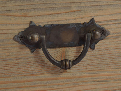 Decorative metal handle on wooden surface