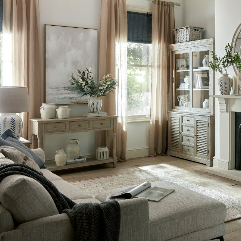 Living room with beige sofa, coffee table, and decorative items.