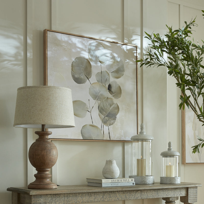 Decorative table setting with a lamp, books, and a plant in a home interior.