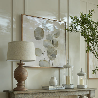 Decorative table setting with a lamp, books, and a plant in a home interior.