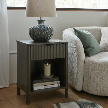 Side table with lamp and books next to a sofa in a living room