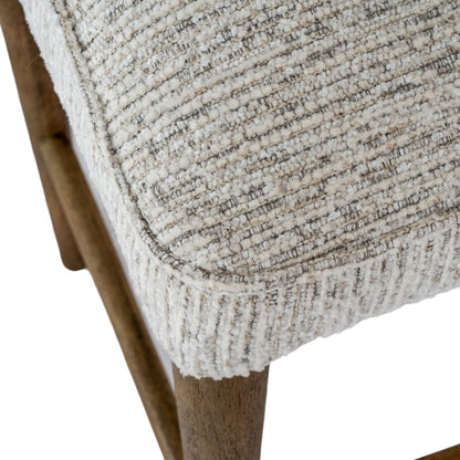 Close-up of a textured fabric seat on a wooden chair