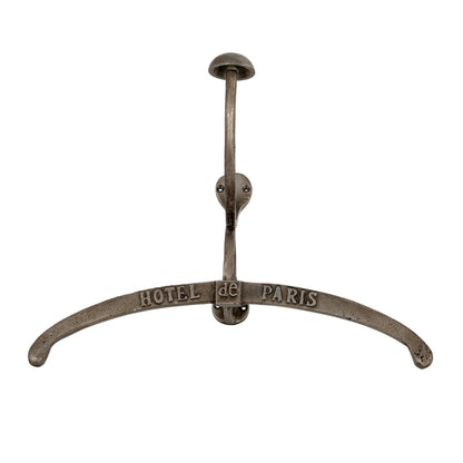Metal coat rack with 'Hotel de Paris' inscription on a white background