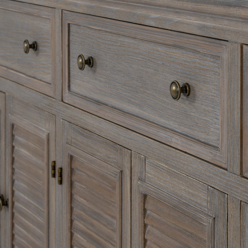 Close-up of a wooden cabinet with drawers and louvered doors.