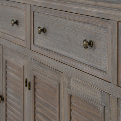 Close-up of a wooden cabinet with drawers and louvered doors.