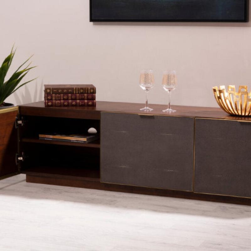 Modern wooden entertainment console with open door, decorative items, and a plant in a minimalistic room.
