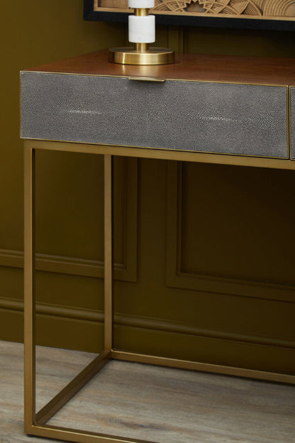 Console table with metallic frame and textured gray drawer in a room setting.